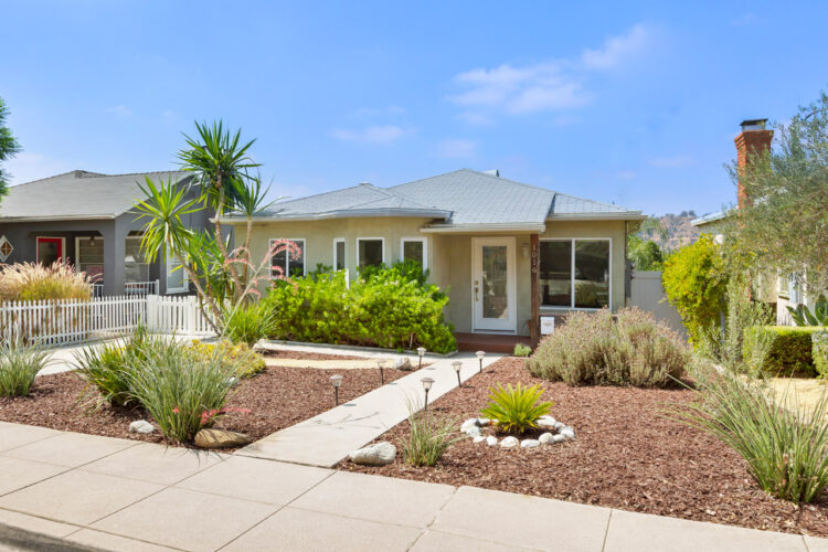 a traditional home painted olive with drought tolerant landscaping