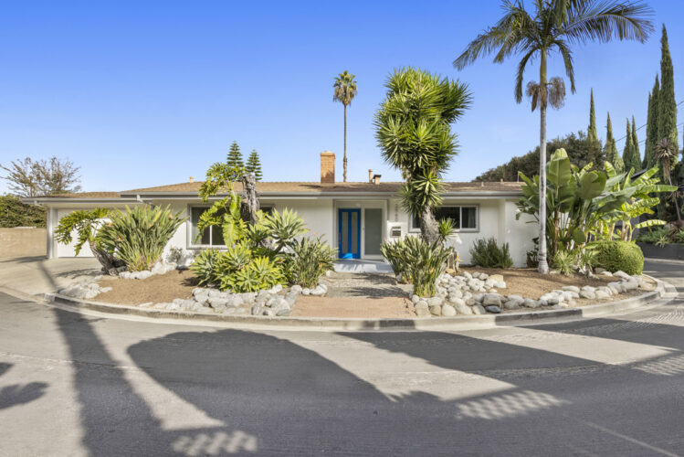 corner lot, mid-century house with a blue door, palm trees