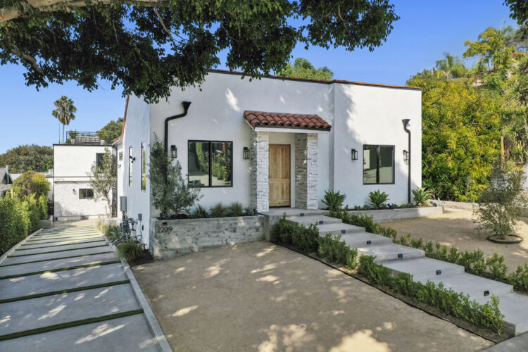 exterior of a white spanish style home with decomposed granite front yard