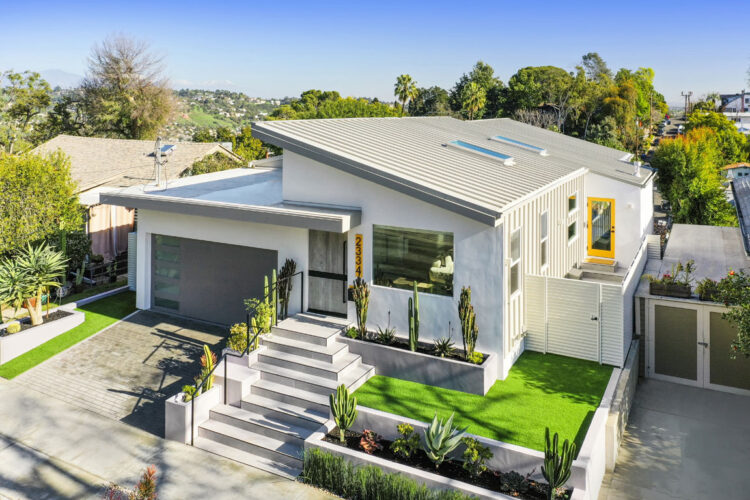 drone shot of the contemporary new build home white and grey with yellow accents