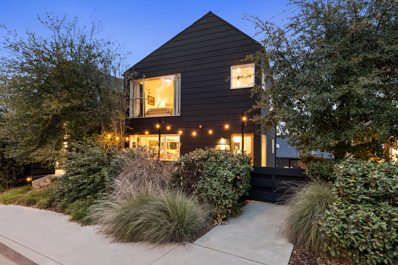 A black painted barabara bestor designed home in echo park, with twinkling lights at twilight