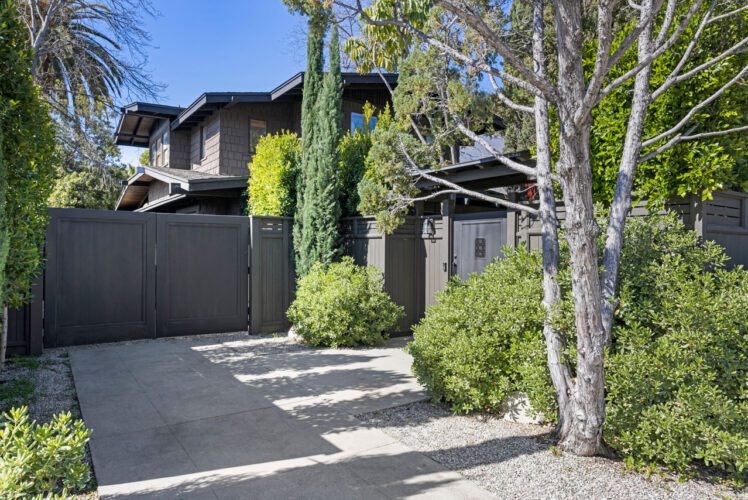 exterior of a black craftsman home with gate