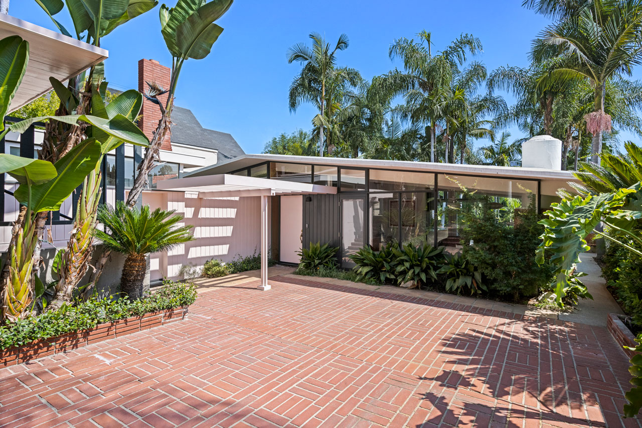 brick courtyard of a mid-century home with palm trees