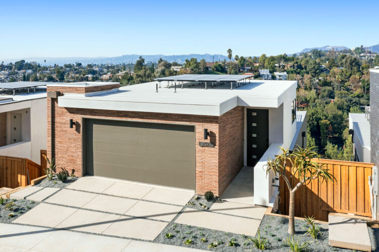 exterior of a new mid-century style home with brick and view of the hollywood hills and sign
