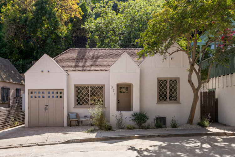 exterior of a tan tudor style cottage with tan accents and green foliage in mt washington los angeles