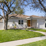 exterior of a traditional style home painted white with a brown roof and green grassy yard