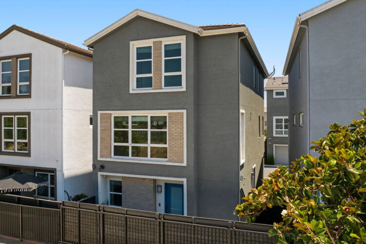 exterior of a three story townhouse painted moss with beige and white accents