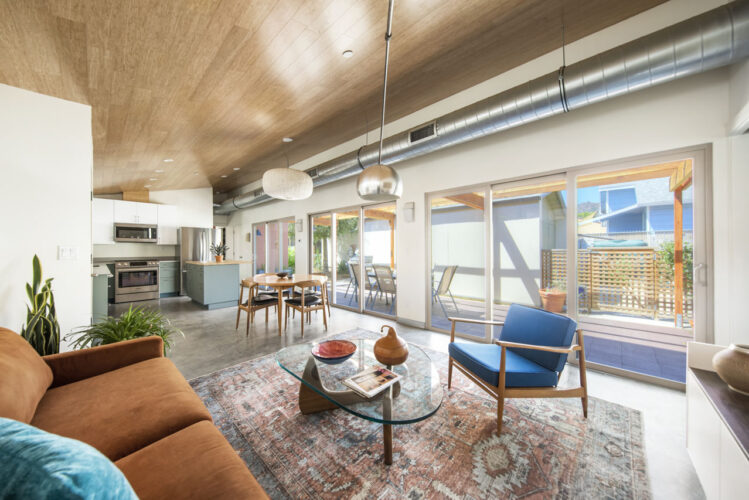 interior of contemporary loft style interior with wide sliding glass doors and a modern kitchen