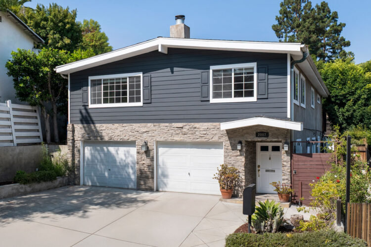 exterior of a two story contemporary home with stone details, blue siding, and white trim