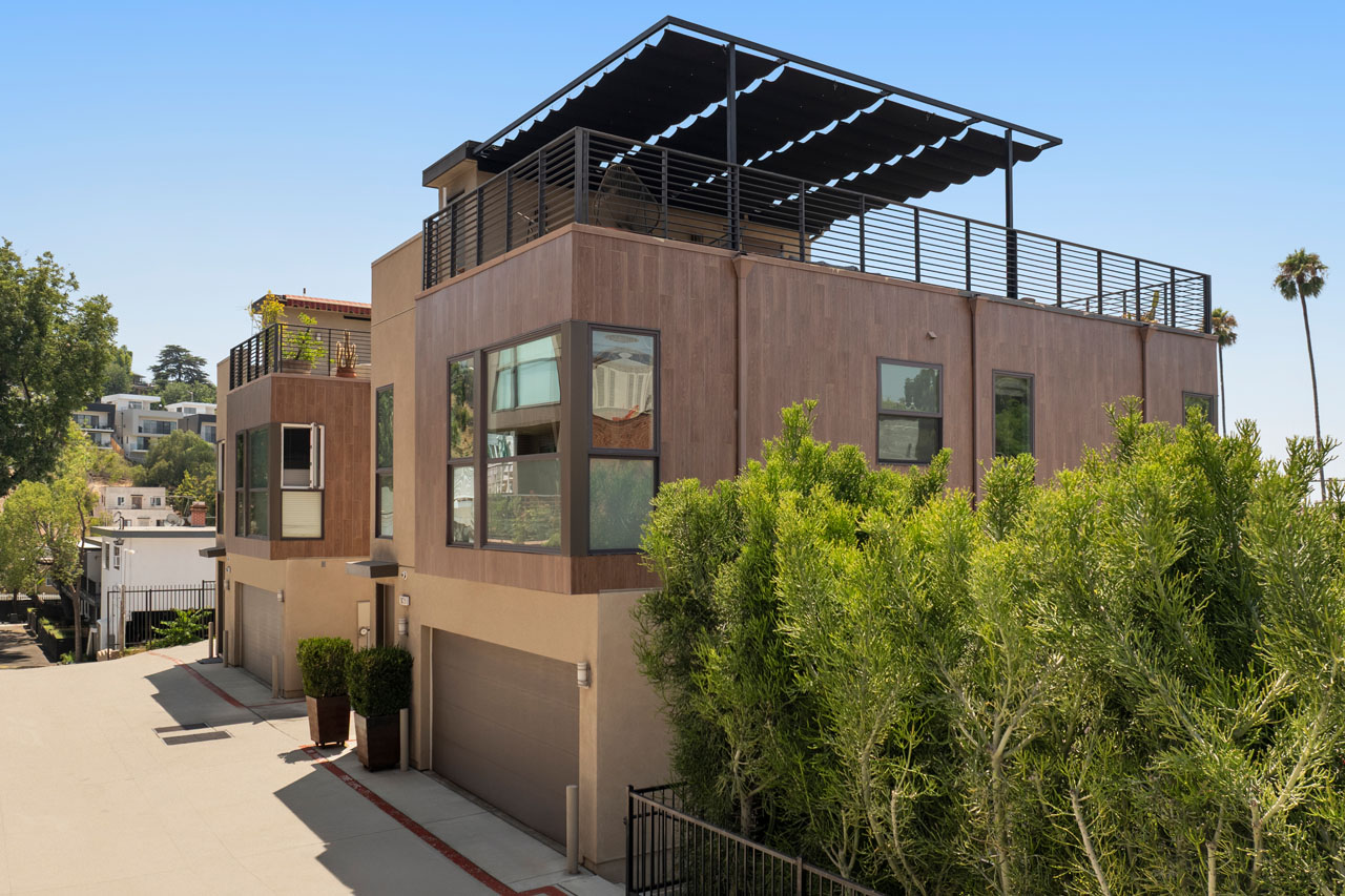 exterior of a three story home with beige exterior and green bamboo