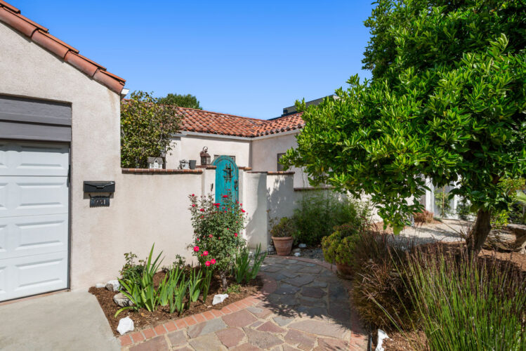 exterior of a spanish style home with tile roof and greenery