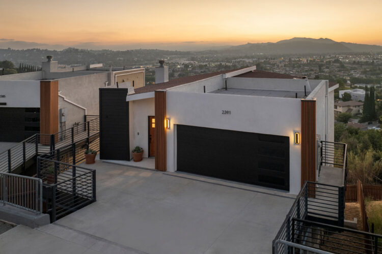 exterior of a contemporary home with white smooth stucco facade, dark brown garage door, and wood accents