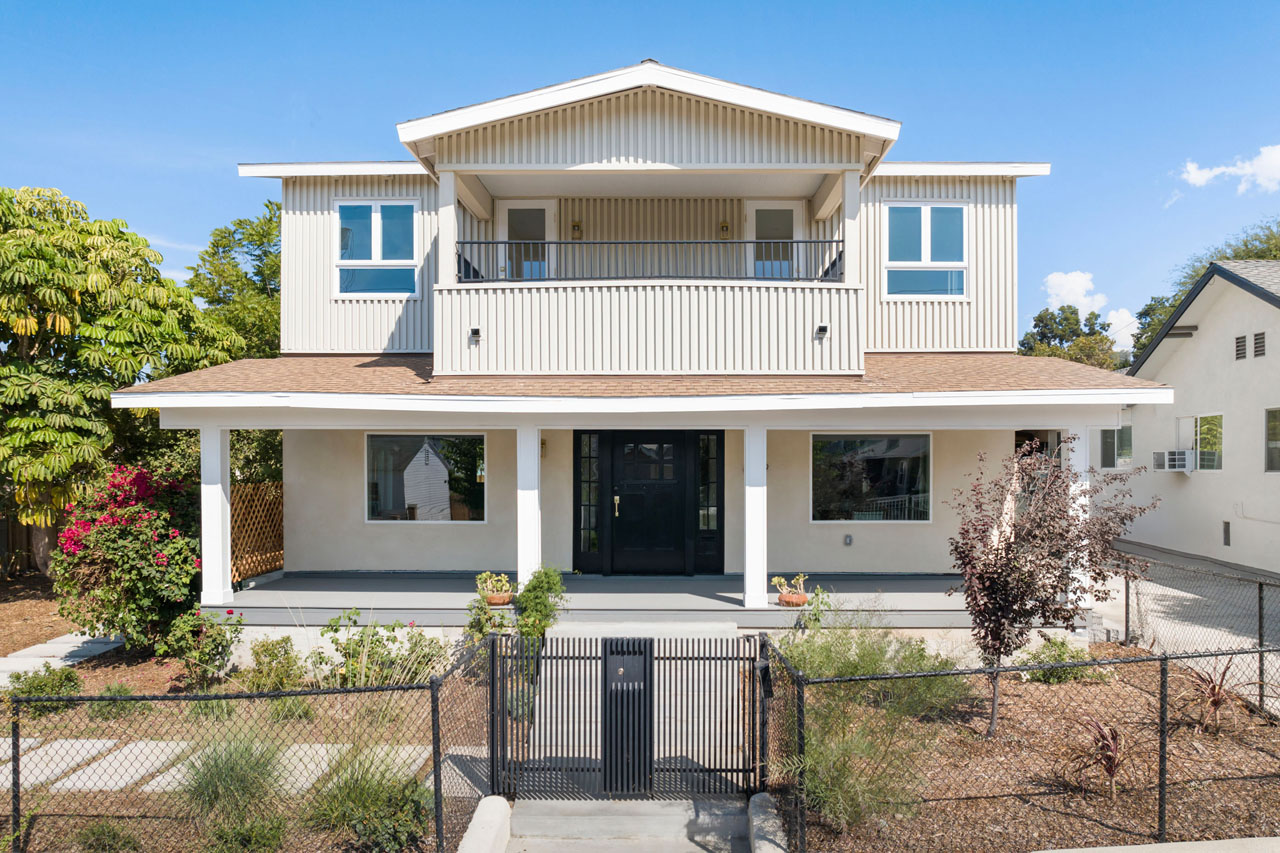exterior of a two story craftsman style home painted beige with brown trim and a drough tolerant front yard