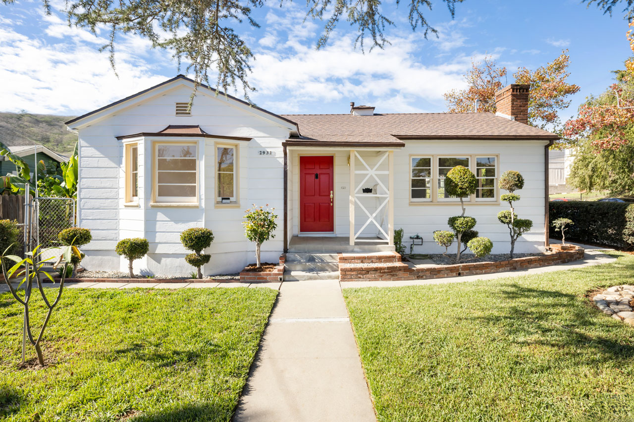 exterior of a traditional style home painted white with a red door