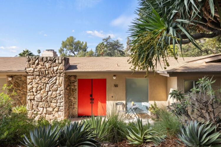 image of a midcentury home on a hillside with canyon views and green foliage