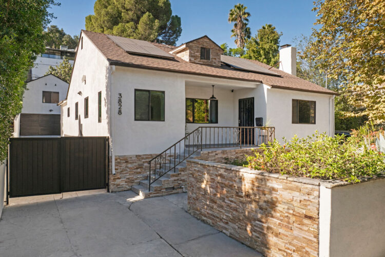 exterior of a traditional home painted white with a stone wall