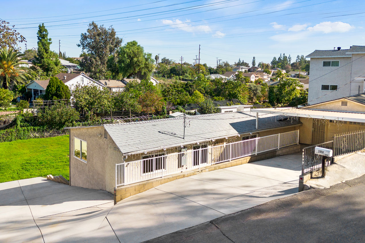 exterior of a beige traditional one story home with green backyard