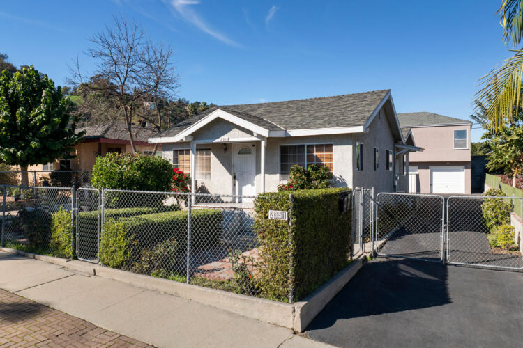 exterior of a traditional single level home painted grey with boxwood hedges