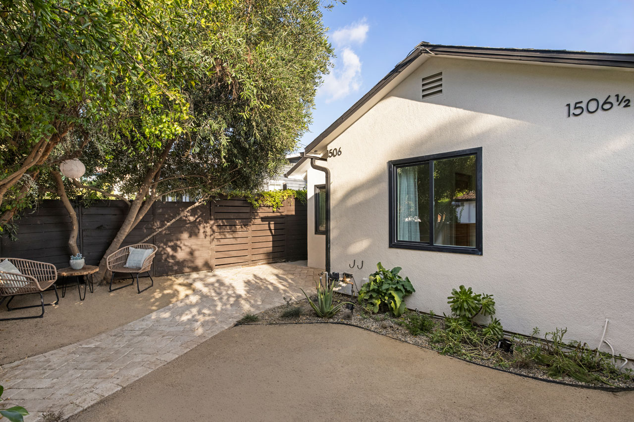 exterior of a traditional home painted white with black trim and decomposed granite front yard