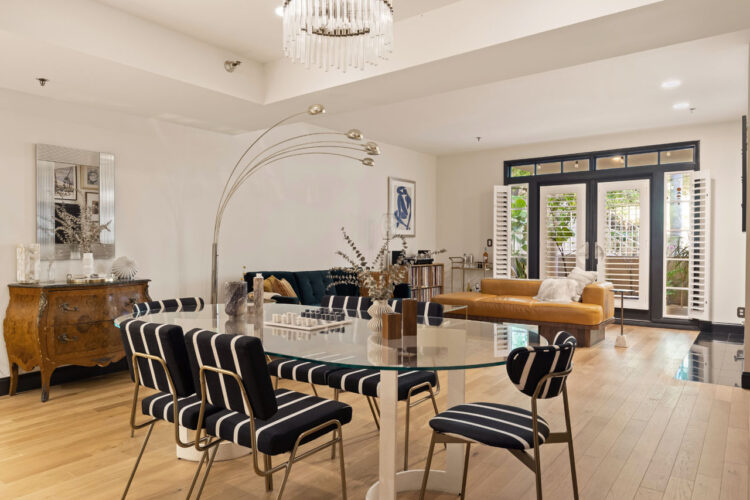 interior of a contemporary condo with wood floors, beige leather couch, fireplace and art on the walls