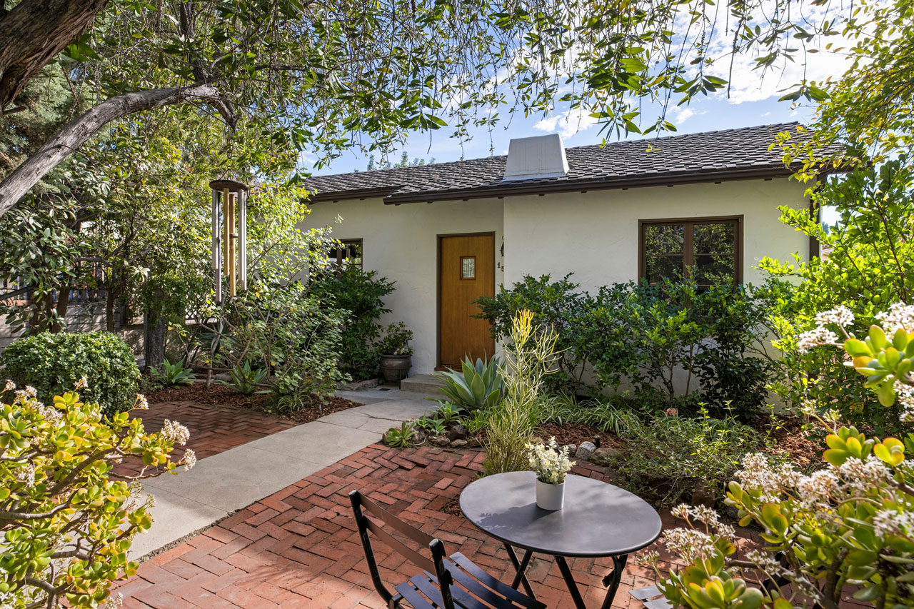 exterior of a traditional home with brick patio and greenery