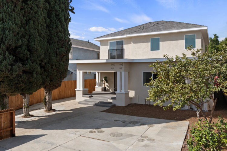 exterior of a two story home community with cypress trees