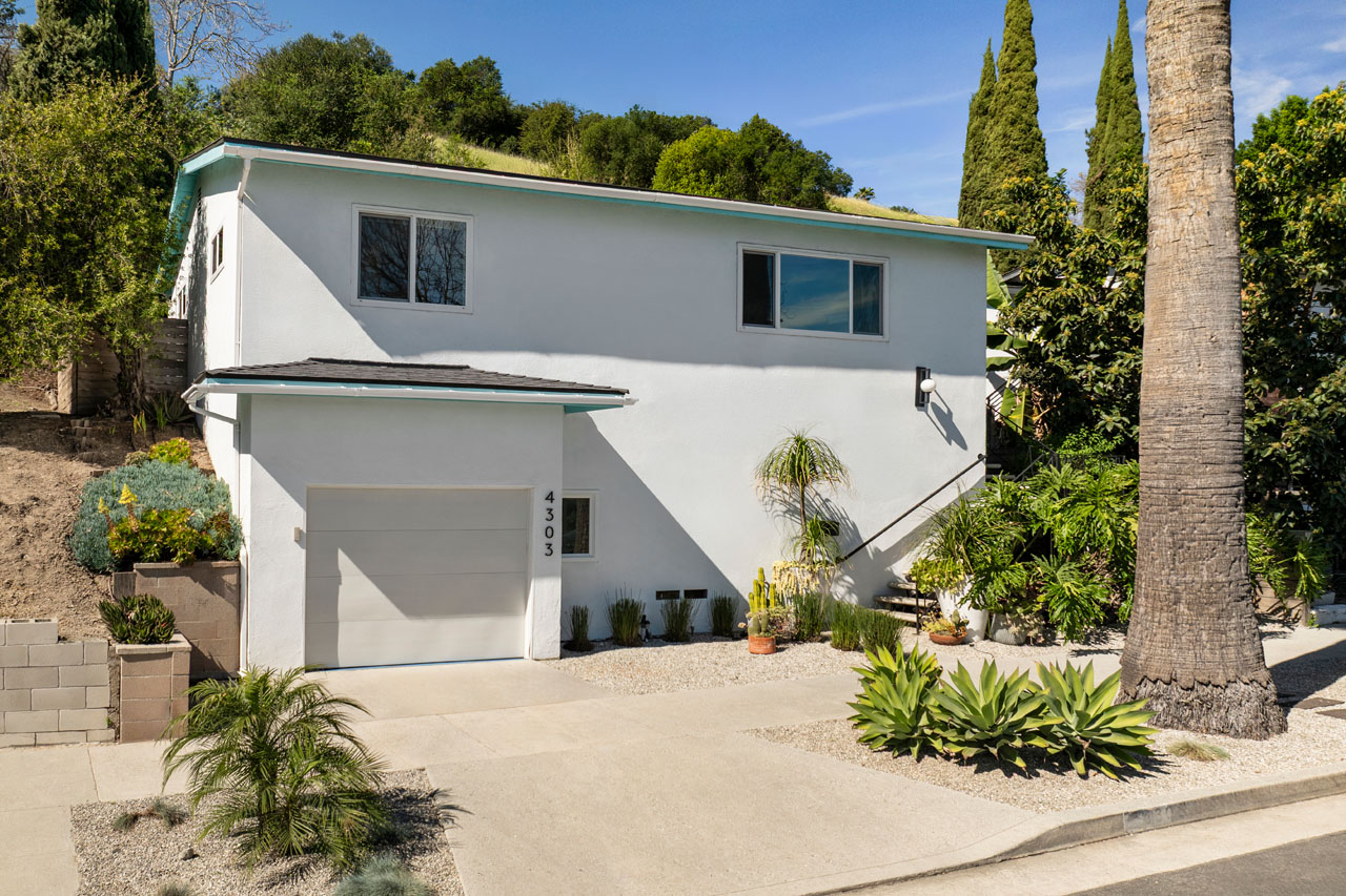 exterior of a traditional home painted white with black trim and blue sky