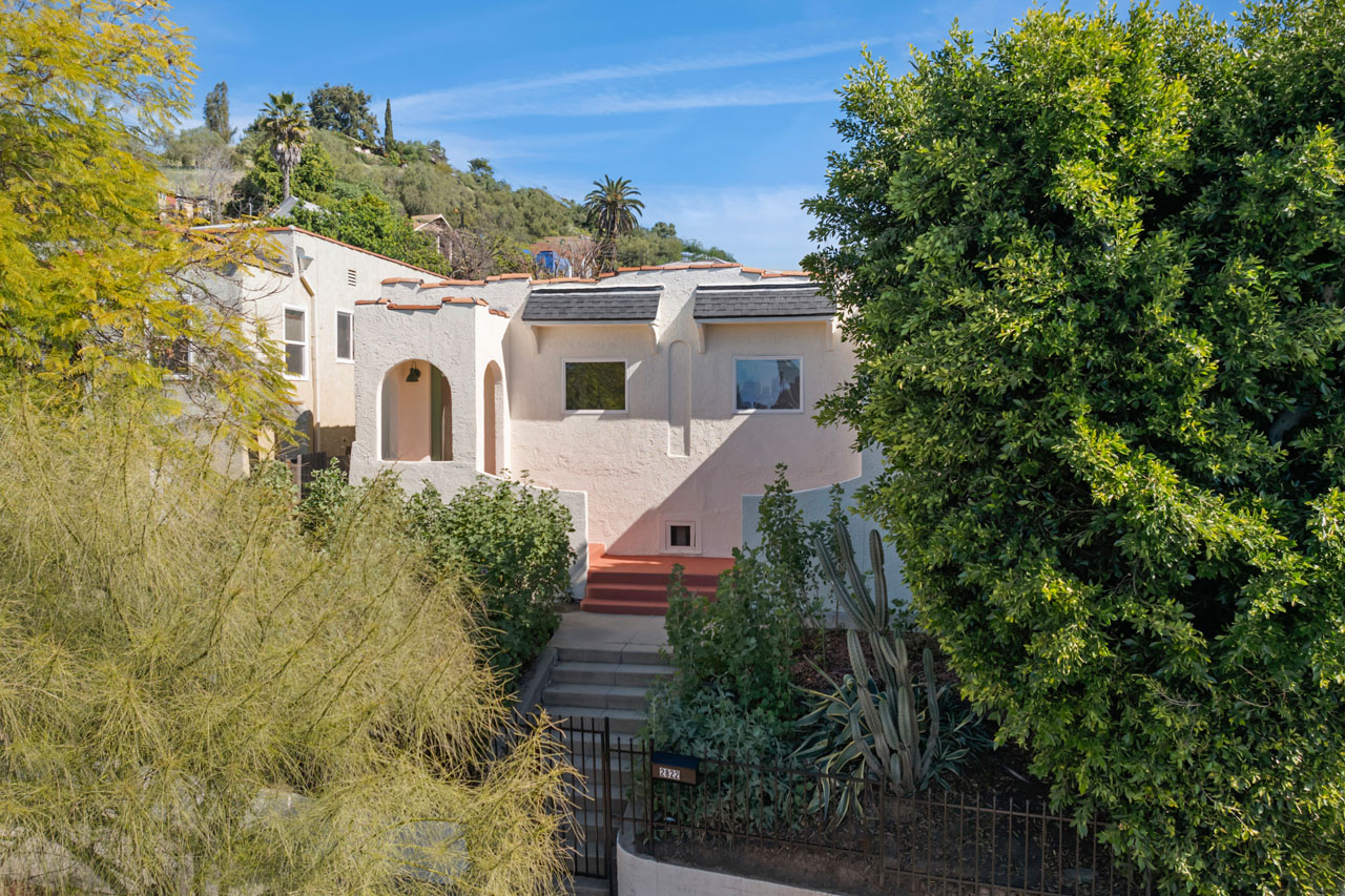 exterior of a spanish style duplex painted white with saltillo tile detail