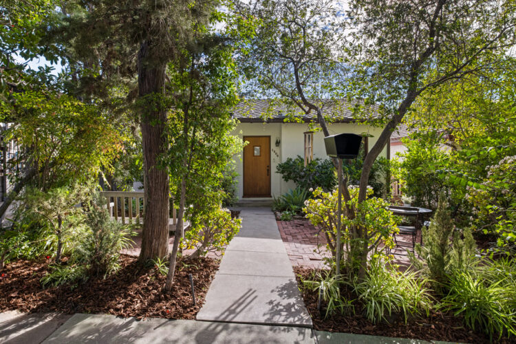 exterior of a traditional home with brick patio and greenery