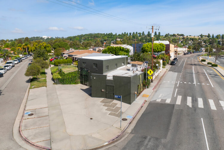 aerial view of a dark grey commercial building on a trangular shaped lot with a boulevard