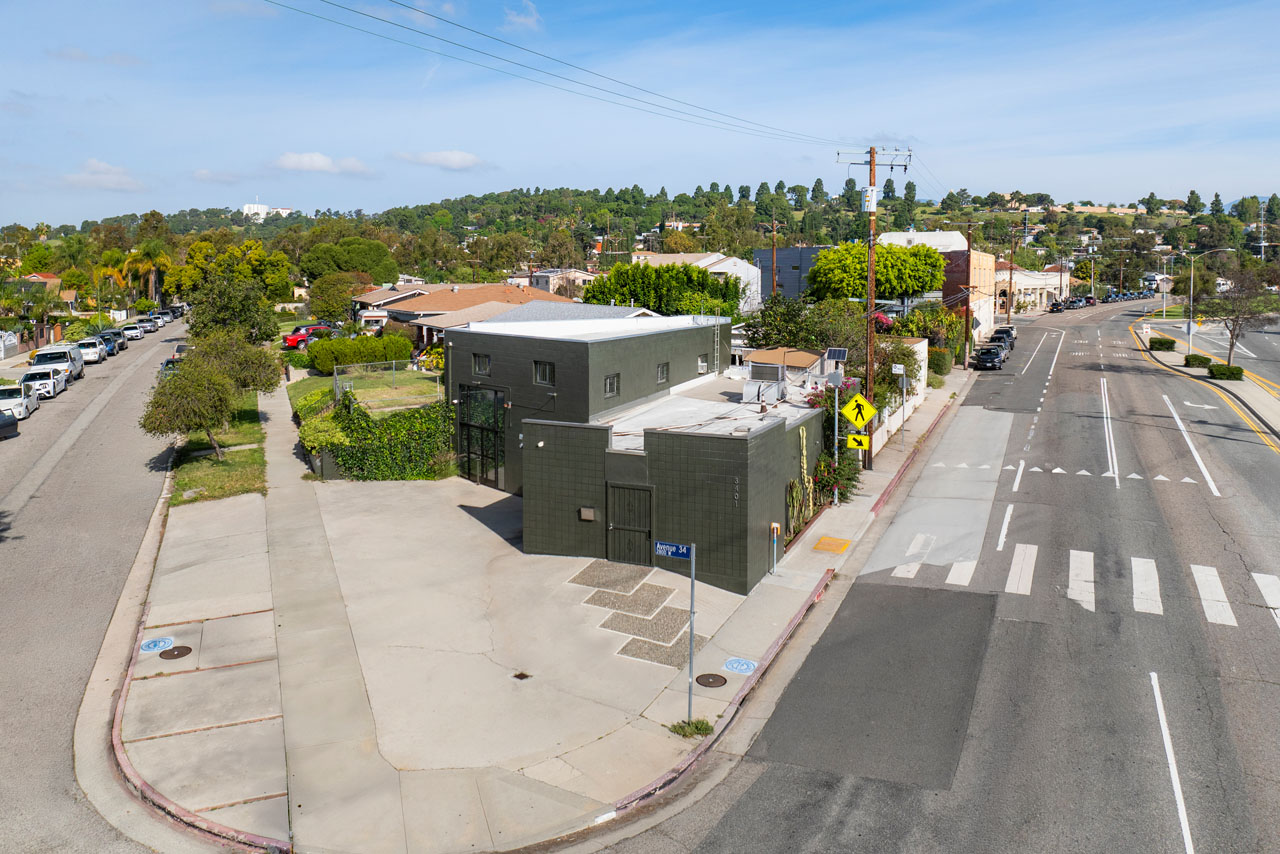 aerial view of a dark grey commercial building on a trangular shaped lot with a boulevard