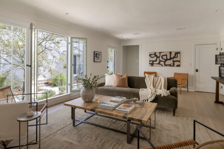 interor of a spanish style tic unit showing windows with drought tolerant landscaping outside and wooden floors with contemporary furniture