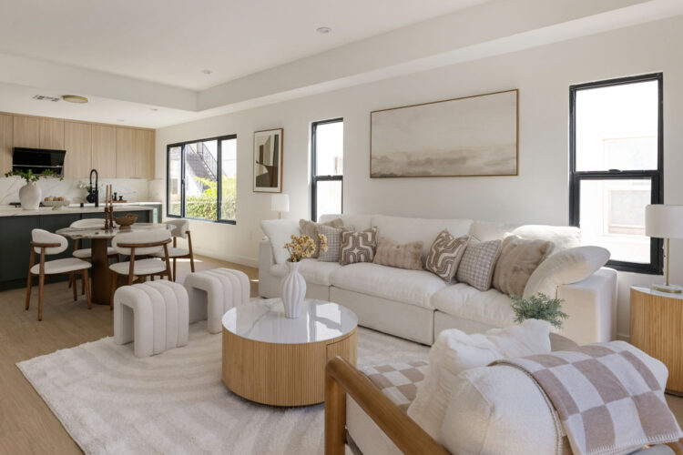 interior of a home showing couches and a designer kitchen with island and green cabinets