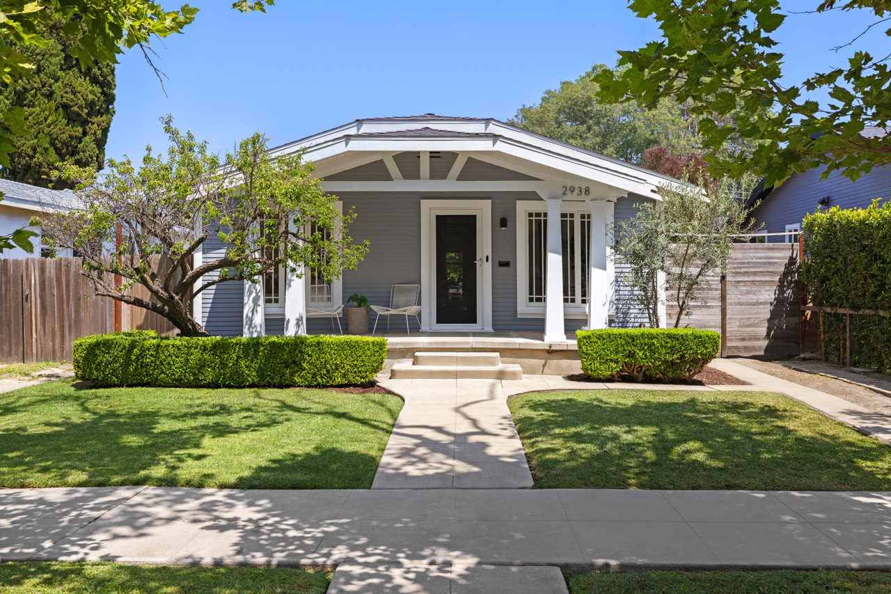 exterior of a craftsman bungalow home painted grey with white trim and green gras yard