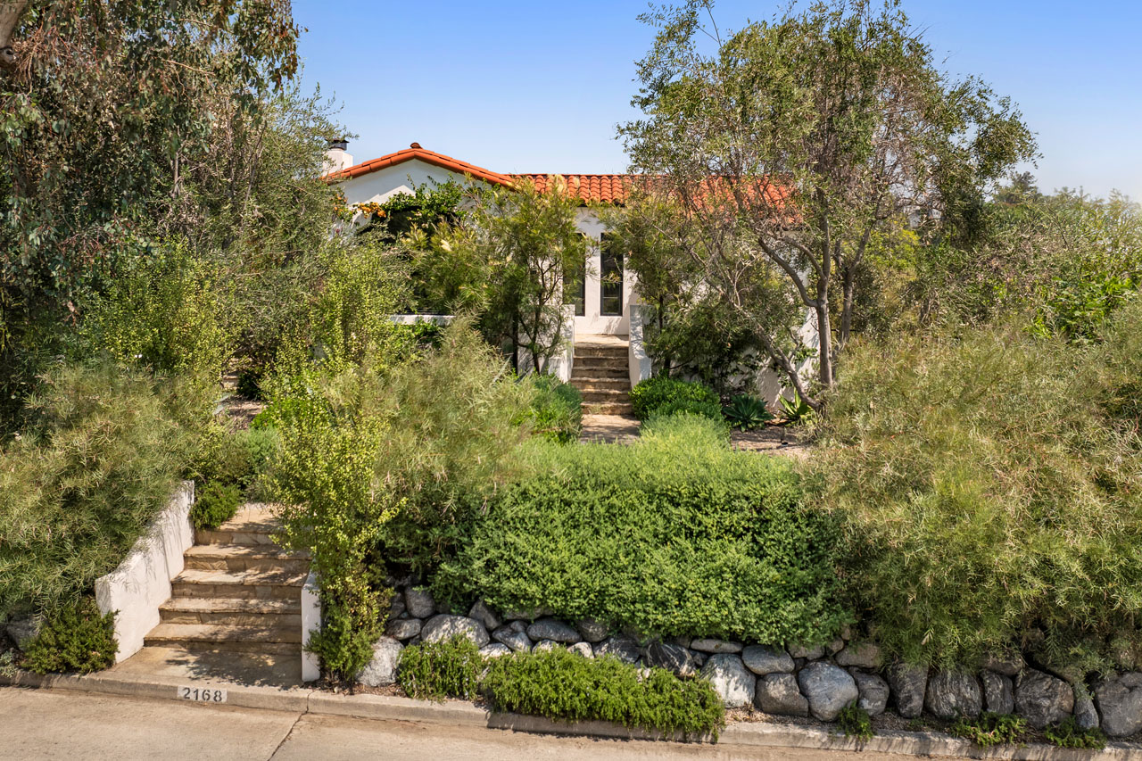 exterior of a beautiful spanish style home with natural plantings