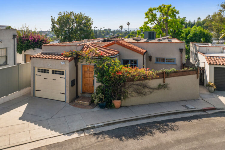 exterior of a spanish style home painted beige with salitillo tile roof