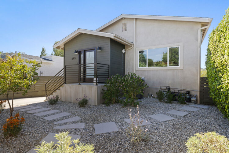 exterior of a contemporary home painted grey with dark grey trim and drought tolerant landscaping