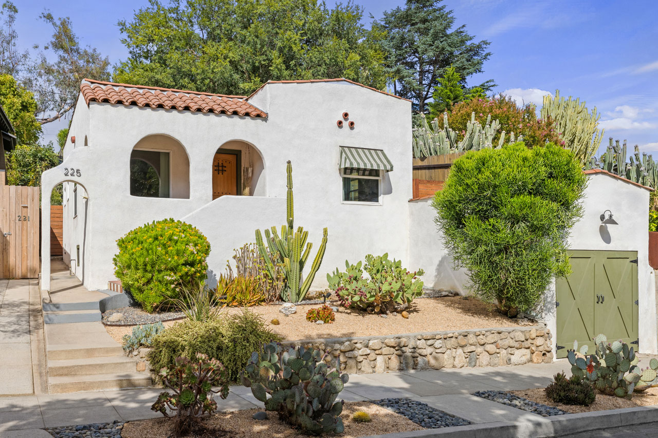 exterior of a white spanish style home with saltillo tile roofs and arched pass throughs