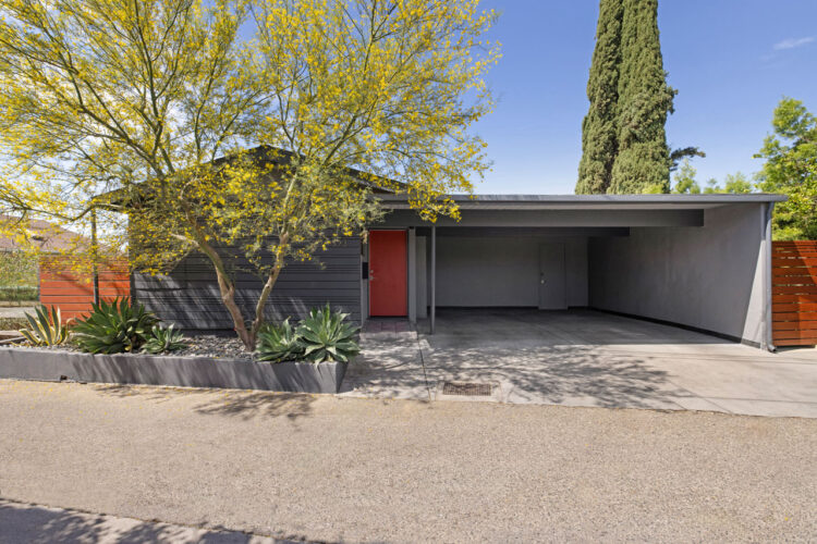 front exterior of a two story mid century home painted in greys with spiral staircase and jacuzzi