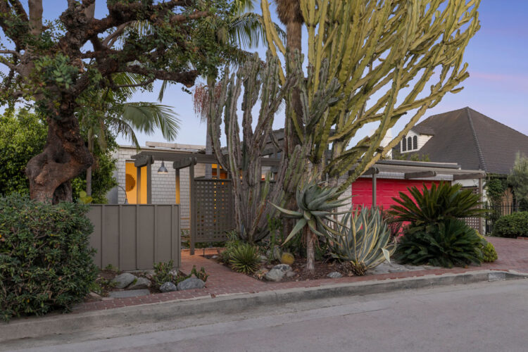 exterior of a postmodern home in silver lake with a large cactus front yard and red garage door