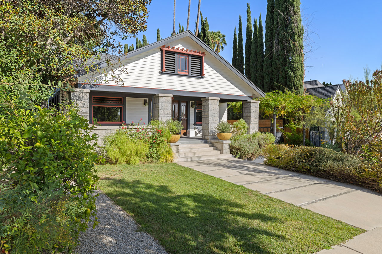 A traditional Silver Lake home in the Moreno Highlands from Tracy Do Real Estate. exterior of a traditional two story home with garage, painted white with black roof cypress tree and brick details