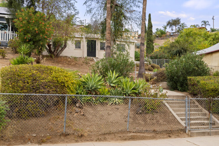3165 Minnesota St Los Angeles, CA 90031 image of a fixer home with white shingles, agave, a chain link fence, and stairs
